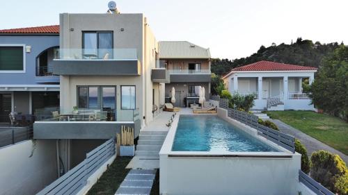an image of a house with a swimming pool at Theros Suites in Dhiminión