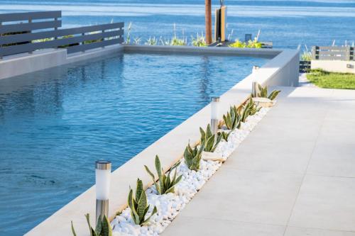 a swimming pool with a bench and the water at Theros Suites in Dhiminión