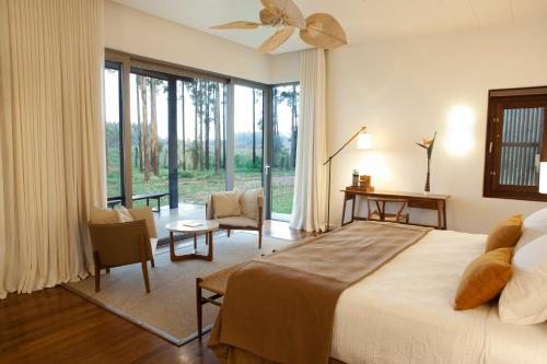 een slaapkamer met een groot bed en een groot raam bij Puerto Valle Hotel de Esteros in Puerto Valle