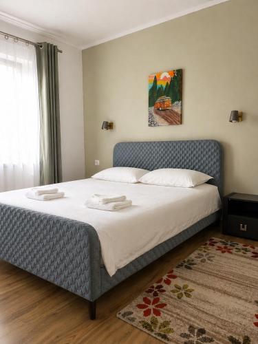 a bedroom with a large bed with white sheets at Casa Liniștea Pădurii in Gura Văii