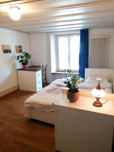 a bedroom with a bed and a table with a lamp at Grosse Charmante Wohnung in Erlach