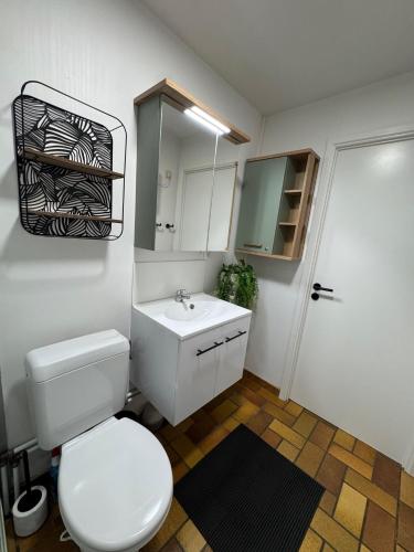 a bathroom with a white toilet and a sink at Les Trois Feuilles in Petit Mesnil