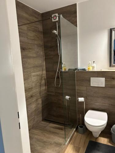 ein Badezimmer mit Glasdusche und WC in der Unterkunft Motel Munsch in Neukirchen-Vluyn