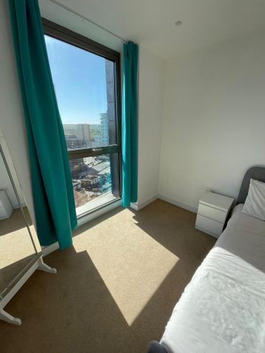 a bedroom with a bed and a large window at LUXURY SERVICED APARTMENT***** in Croydon