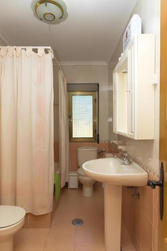 a bathroom with a sink and a toilet and a shower at La Veiga Apartamentos Turísticos in La Riera