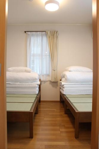 two beds in a room with a window at 2026APR NEW Open! SETOUCHI BLUE BASE in Utazu