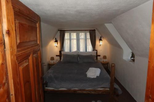 a bedroom with a bed and a window at Casa Plaiul Cailor: Rustic Mountain Hideaway in Proviţa de Sus