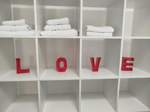 a white shelf with towels and the word love at Ferienwohnung Friederike Luise in Bad Freienwalde