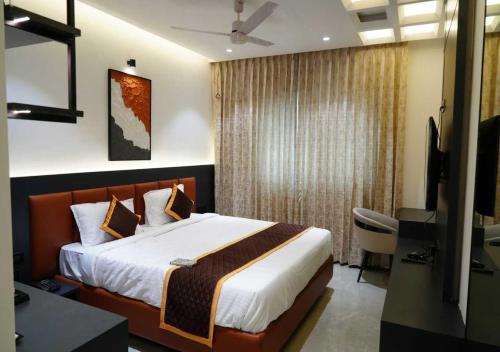 a bedroom with a bed and a desk and a television at K R GRAND in Vijayawāda