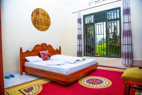 a bedroom with a bed and a large window at Virunga House in Ruhengeri