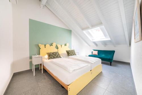 a bedroom with a large bed and a blue chair at Residenza Motta - Boutique Apartments in Locarno
