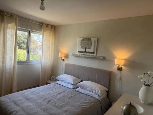 a bedroom with a bed with two pillows and a window at L'appart des lutins in Pornic