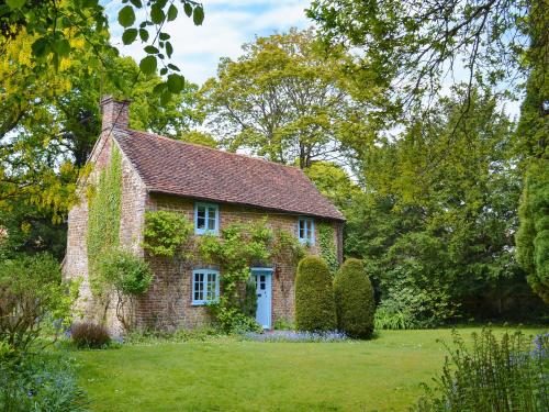 an old brick house in the middle of a field at Yew Tree Cottage in Arford