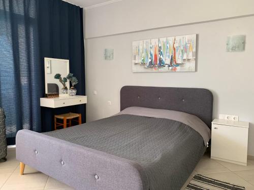 a bedroom with a bed and a blue curtain at Sea view studio in Loutraki