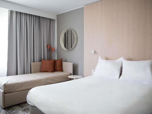a hotel room with a bed and a couch at Novotel Antwerpen - Ekeren in Antwerp
