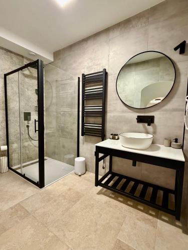 un baño con lavabo y ducha con espejo en Arena Prestige Rooms, en Pula