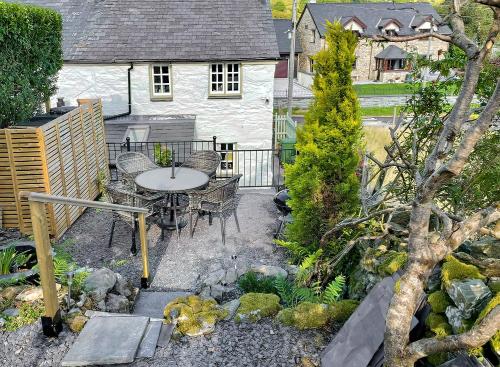 a patio with a table and chairs in a garden at Summerhill Tanyrhos in Blaenau-Ffestiniog