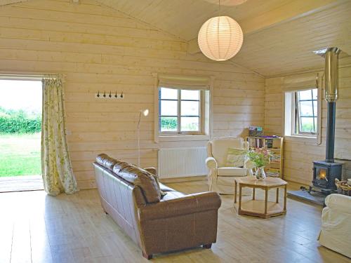 a living room with a couch and a fireplace at Skylark Lodge - Uk51678 in Carsethorn
