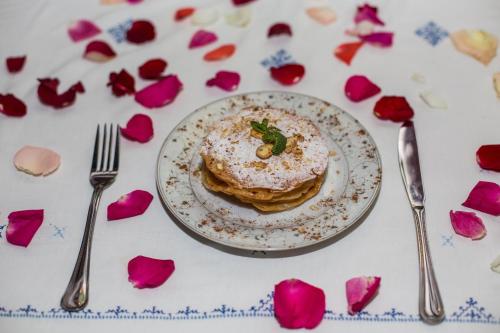 a plate of pancakes on a table with flowers at Riad Sara in Fès