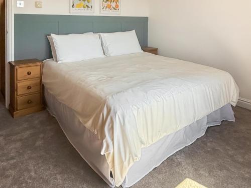 a bedroom with a large bed and a night stand at The Granary - Uk50171 in Mare Green