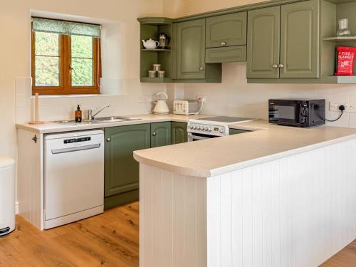a kitchen with green cabinets and a counter top at The Granary - Uk50171 in Mare Green