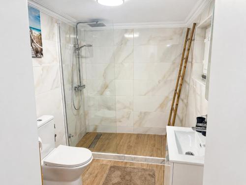 a bathroom with a shower and a toilet and a sink at Modern Studio with Private Patio near Cascais & Sintra in Alcabideche