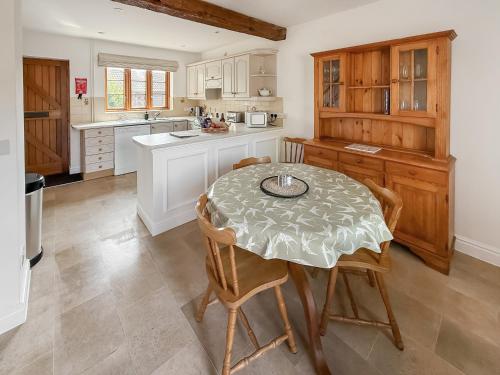 a kitchen with a table and chairs in a kitchen at The Swallows - Uk50177 in Mare Green