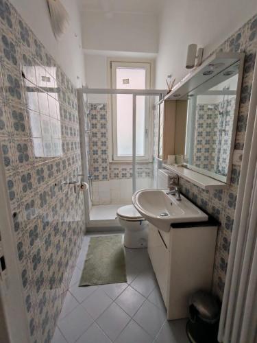 a bathroom with a sink and a toilet and a mirror at San bernardo guest house in Fossano