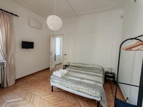 a white room with a bed and a television at San bernardo guest house in Fossano