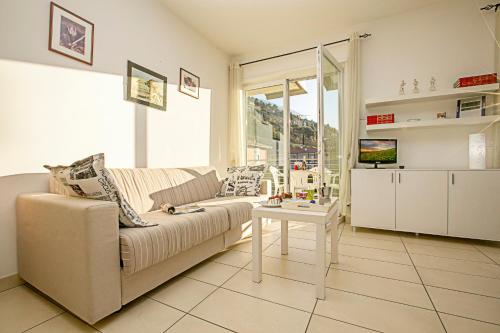 a living room with a couch and a table at Torbole Relax, Pool & Balcony Apartment in Nago-Torbole
