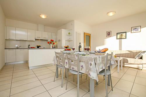 a kitchen and living room with a table and chairs at Torbole Relax, Pool & Balcony Apartment in Nago-Torbole