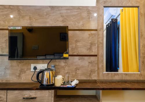 a mirror on a wall above a counter with a blender at Hidden Leaf in Dehradun