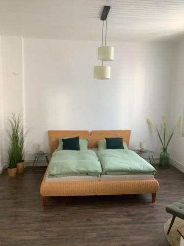 a bedroom with a bed with green sheets at Ruhrpott Liebe in Herten