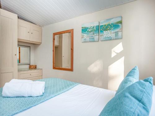 a bedroom with a white bed and a mirror at Skylarks in Saint Merryn