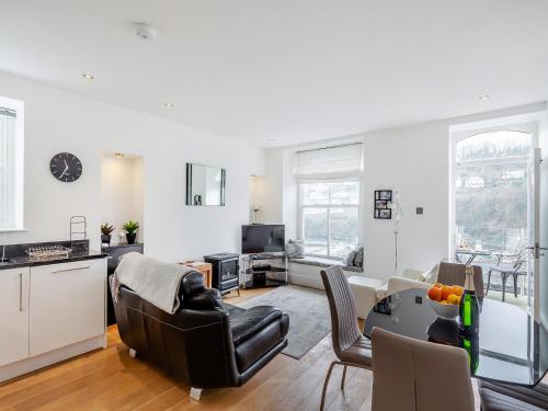 a kitchen and living room with a table and chairs at Gwendrock Diw in Looe