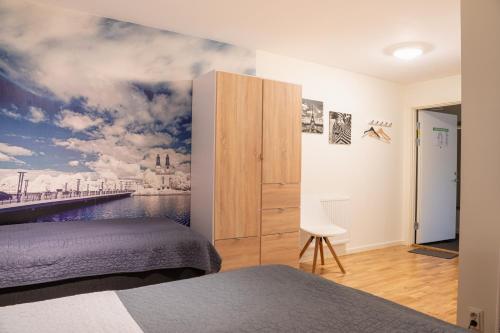 a bedroom with a painting on the wall at Hotell TunaPark in Eskilstuna