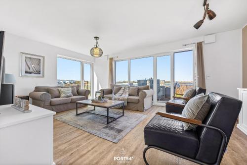 a living room with a couch and a table at Ferienhaus Hamptons Beach House Olpenitz in Olpenitz