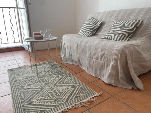 a living room with a couch and a rug at Studio in Fayence