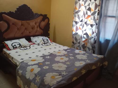 a bedroom with a bed with a flowery comforter at RESIDENCE MEUBLEe BOBO LAFIA in Bobo-Dioulasso