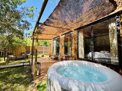 a hot tub on the deck of a house at Bambou Lodge & Spa in Arles