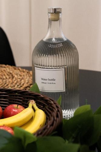a bottle of water and a basket of apples and bananas at Das Nomadenhaus - Garten, Grill, Nähe Köln in Bergheim