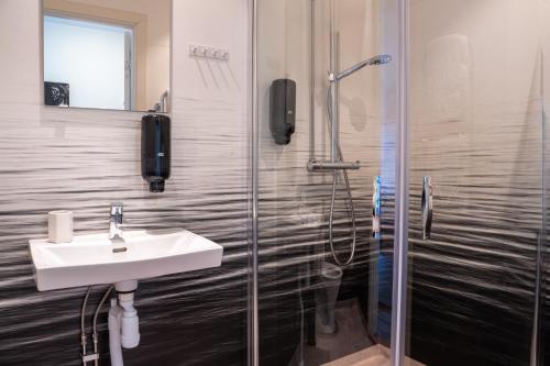a bathroom with a sink and a shower at Hotell TunaPark in Eskilstuna