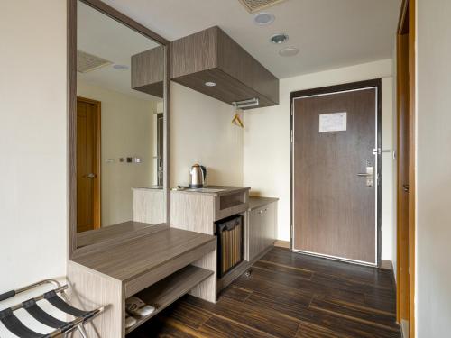 a kitchen with a counter and a sink and a mirror at West Hotel in Puli
