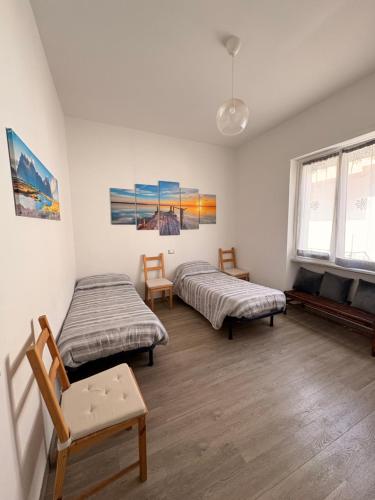 a room with two beds and a chair in it at Susy's Home Appartamento in centro in Corchiano