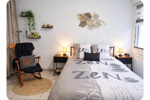 a bedroom with a bed and a chair at Meublé 3 étoiles en centre-ville in Niederbronn-les-Bains