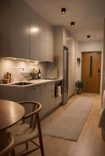 a kitchen with stainless steel appliances and a table at Modern studio with balcony in Stockholm