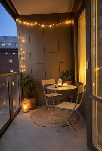 a table and chairs on a balcony with lights at Modern studio with balcony in Stockholm