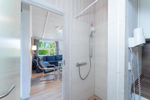 a bathroom with a walk in shower next to a living room at Schmugglerstieg - Dorf Ferienhaus 03 in Priwall