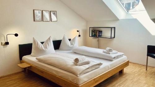 a large white bed with white pillows on it at FeWo Alpenglühen in Gmund am Tegernsee