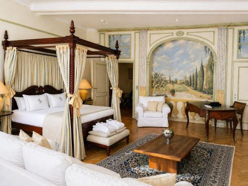 a bedroom with a canopy bed and a living room at Hotel Le Dixseptième in Brussels